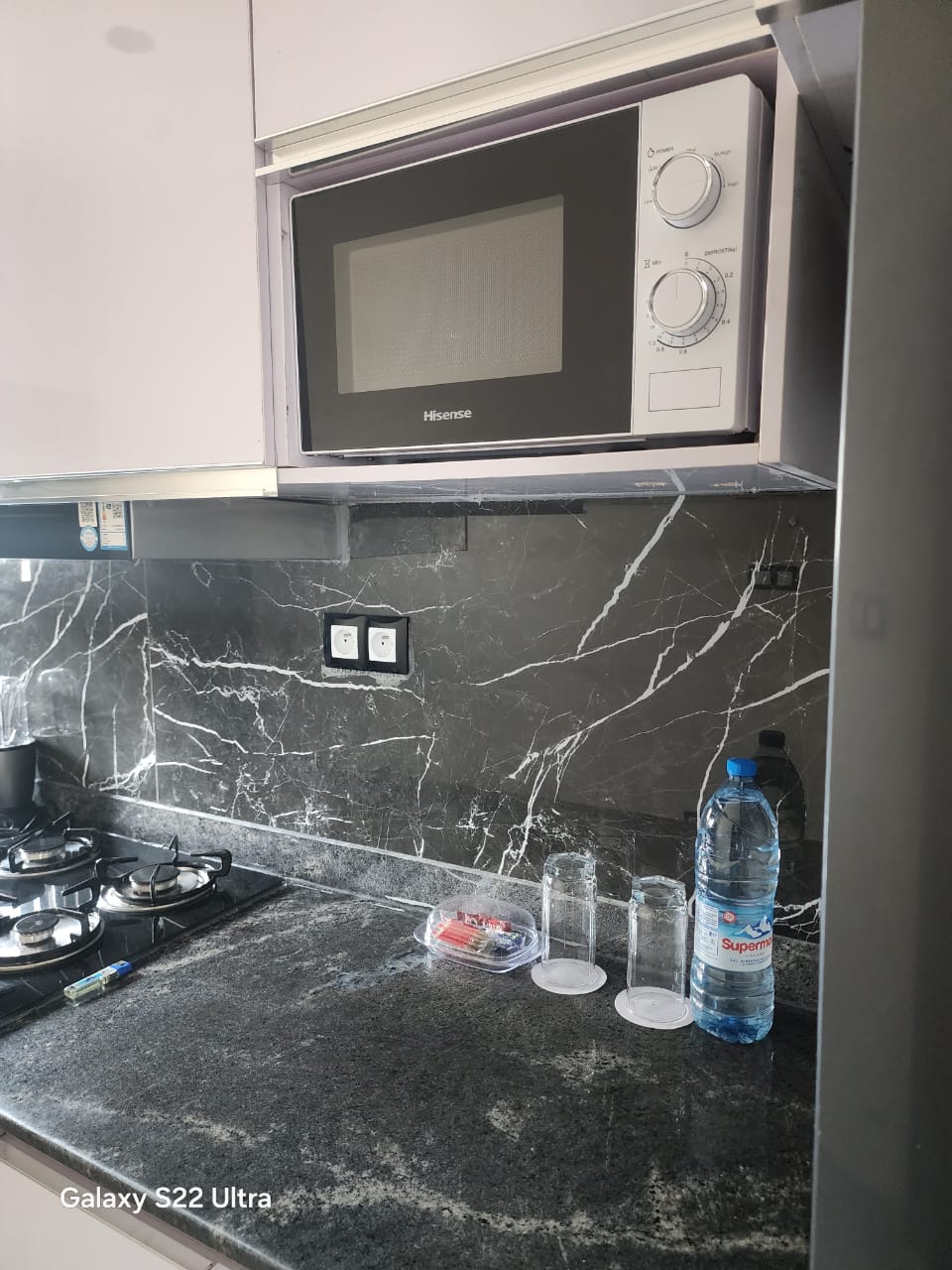 Fitted kitchen with black marble worktop and splashback
